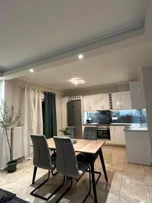 a kitchen with a wooden table and chairs at Kosmos luxury apartment in Athens