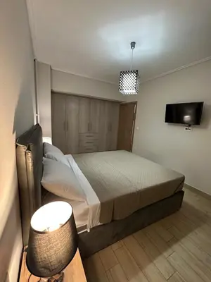 a bedroom with a bed and a flat screen tv at Kosmos luxury apartment in Athens