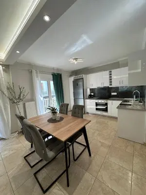 a kitchen and dining room with a wooden table and chairs at Kosmos luxury apartment in Athens