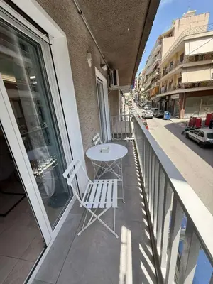 a table and chairs on the balcony of a building at Kosmos luxury apartment in Athens