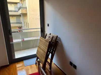 a wooden chair sitting in a room with a window at Cozy apartment in Athens in Athens
