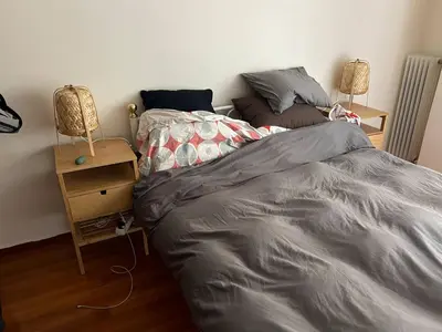 a bedroom with a bed and a night stand with a lamp at Cozy apartment in Athens in Athens