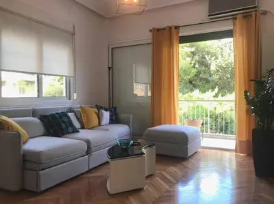 a living room with a couch and a large window at Central flat in Pagrati in Athens