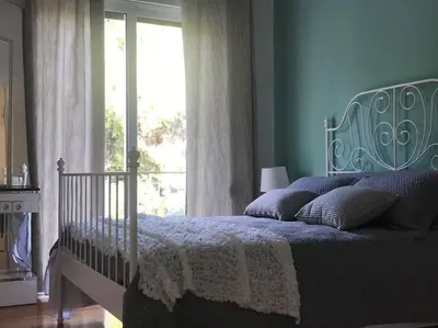 a bedroom with a bed with blue walls and a window at Central flat in Pagrati in Athens
