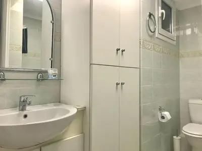 a white bathroom with a sink and a toilet at Central flat in Pagrati in Athens