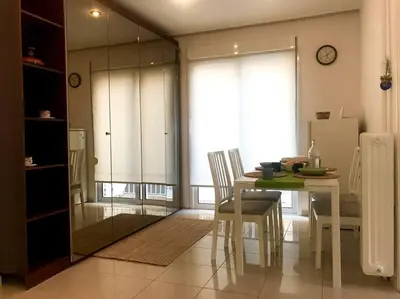 a dining room with a table and chairs and a window at Central flat in Pagrati in Athens