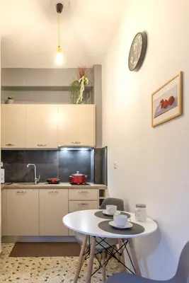 a kitchen with a table and a clock on the wall at Your perfect choice for stay in Athens in Athens