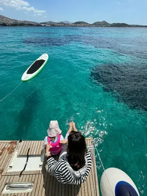 a woman and a child on a boat in the water at Luxury Sailing Cruises in Athens with Traditional Greek Cuisine and Drinks in Athens