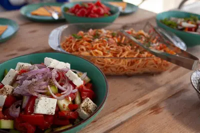 a table with bowls of food and a bowl of pasta at Luxury Sailing Cruises in Athens with Traditional Greek Cuisine and Drinks in Athens
