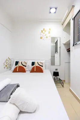 a white bedroom with a white bed and a mirror at AIOLOS glyfada centre apartment 2 in Athens