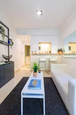 a living room with a white couch and a table at AIOLOS glyfada centre apartment 2 in Athens