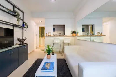 a living room with a white couch and a table at AIOLOS glyfada centre apartment 2 in Athens