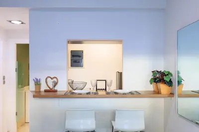 a kitchen with two white stools and a counter at AIOLOS glyfada centre apartment 2 in Athens