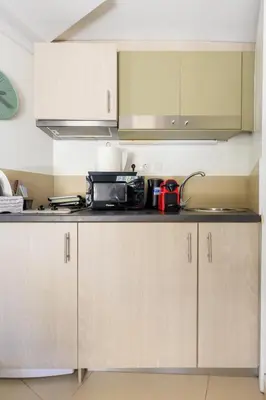 a kitchen with white cabinets and a counter top at AIOLOS glyfada centre apartment 3 in Athens