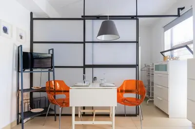 a dining room with orange chairs and a white table at AIOLOS glyfada centre apartment 3 in Athens
