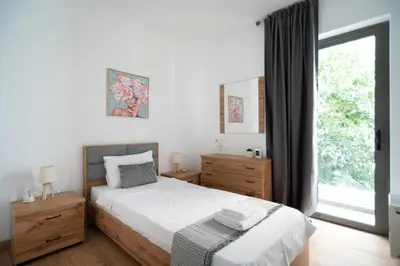 a bedroom with a bed and a large window at Elegant apartment in Agia Paraskevi-B2 in Athens