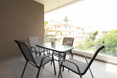 a table and chairs in a room with a large window at Elegant apartment in Agia Paraskevi-B2 in Athens