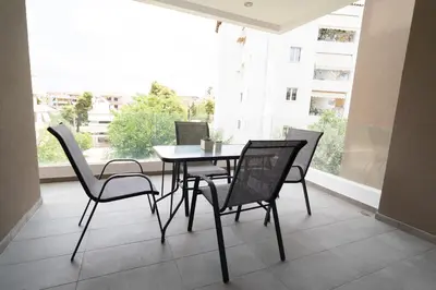 a table and chairs on a balcony with a window at Elegant apartment in Agia Paraskevi-B2 in Athens