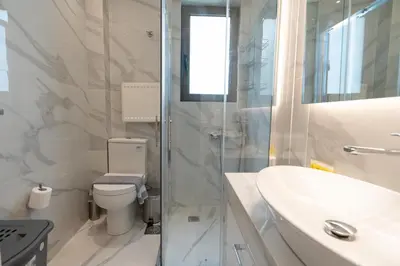 a white bathroom with a toilet and a sink at Elegant apartment in Agia Paraskevi-B2 in Athens