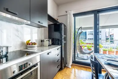 a kitchen with stainless steel appliances and a large window at Stylish 2bed home in Syntagma area in Athens