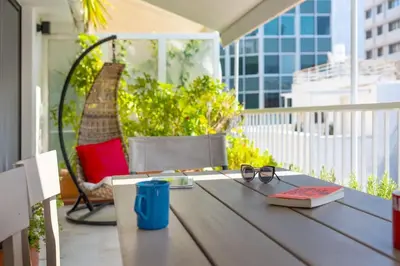 a table with a book and glasses on a balcony at Stylish 2bed home in Syntagma area in Athens