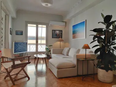 a living room with a white couch and a potted plant at Stylish 1BR Apt with Retro Kitchen View Balcony in Athens