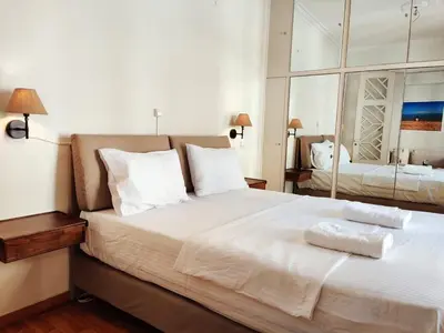 a bedroom with a large bed with two towels on it at Stylish 1BR Apt with Retro Kitchen View Balcony in Athens