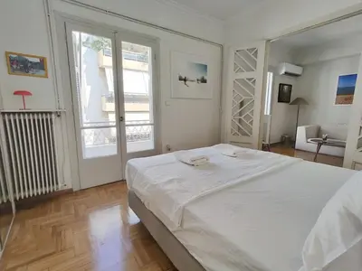 a bedroom with a large white bed and a window at Stylish 1BR Apt with Retro Kitchen View Balcony in Athens