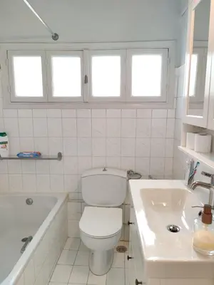 a white bathroom with a toilet and a sink at Stylish 1BR Apt with Retro Kitchen View Balcony in Athens