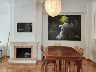 a dining room with a table and a painting at Stylish 1BR Apt with Retro Kitchen View Balcony in Athens