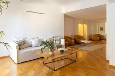 a living room with a white couch and a table at Acropolis Museum Retreat - 2 Bedroom Apartment in Athens