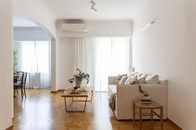 a white living room with a couch and a table at Acropolis Museum Retreat - 2 Bedroom Apartment in Athens