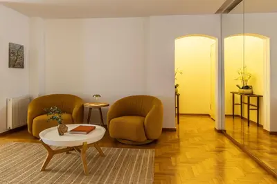 a living room with two chairs and a table at Acropolis Museum Retreat - 2 Bedroom Apartment in Athens