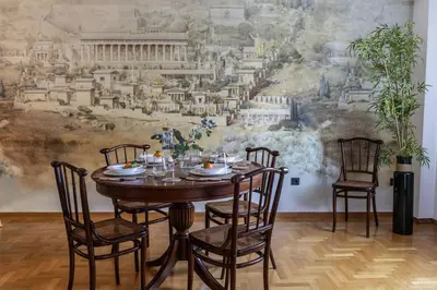 a dining room with a table and chairs in front of a mural at Acropolis Museum Retreat - 2 Bedroom Apartment in Athens