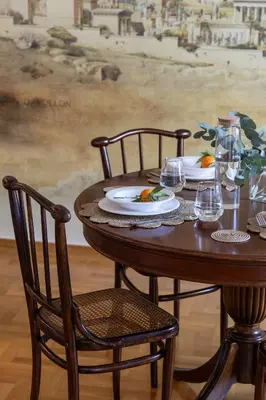 a wooden table with two chairs and plates on it at Acropolis Museum Retreat - 2 Bedroom Apartment in Athens