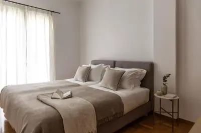 a bedroom with a large bed with a book on it at Acropolis Museum Retreat - 2 Bedroom Apartment in Athens