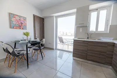 a kitchen and dining room with a table and chairs at City-View Apartment by Piraeus Port - DRF2 in Piraeus