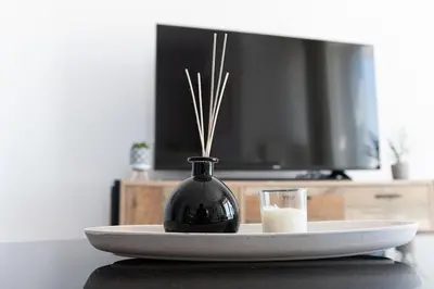 a black vase on a plate with a glass of milk at City-View Apartment by Piraeus Port - DRF2 in Piraeus