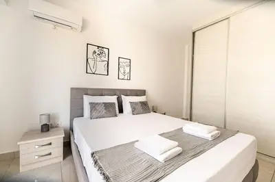 a white bedroom with a large bed and a window at City-View Apartment by Piraeus Port - DRF2 in Piraeus