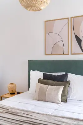 a bedroom with a bed with a green headboard at Athenian 3BR seaside property in Alimos by UPSTREET in Athens