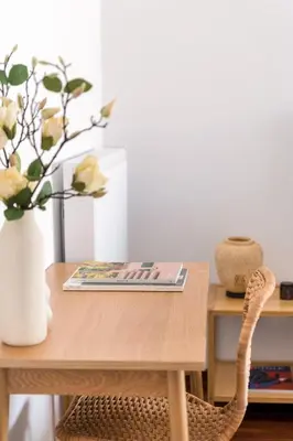 a wooden table with a vase of flowers on it at Athenian 3BR seaside property in Alimos by UPSTREET in Athens