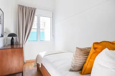 a white bedroom with a bed and a window at Modern Apt opposite the Acropolis Museum in Athens
