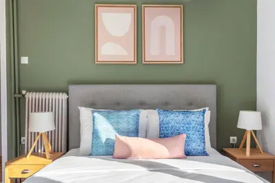 a bedroom with a bed with blue and pink pillows at Modern Apt opposite the Acropolis Museum in Athens