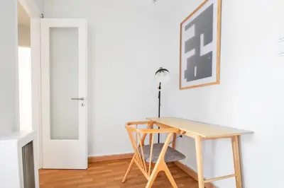 a wooden table and chair in a room with a door at Modern Apt opposite the Acropolis Museum in Athens