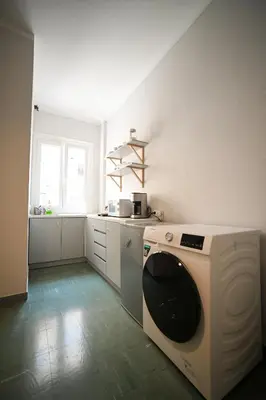 a white kitchen with a washing machine in it at Athenian Suite by Zeussuites in Athens