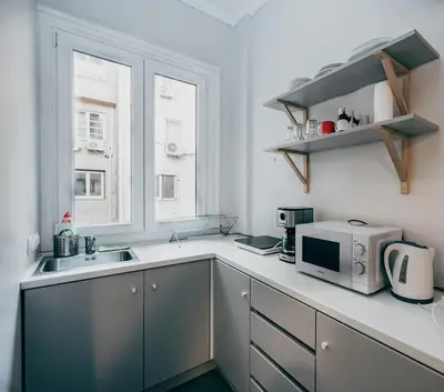 a kitchen with a microwave and a sink and a window at Athenian Suite by Zeussuites in Athens