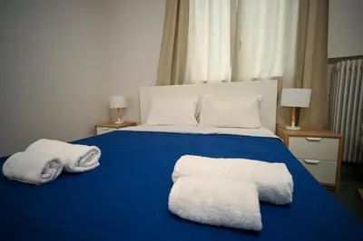 a bedroom with a blue bed with two towels on it at Athenian Suite by Zeussuites in Athens