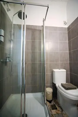 a bathroom with a toilet and a glass shower at Athenian Suite by Zeussuites in Athens