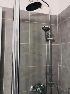 a shower with a shower head in a bathroom at Athenian Suite by Zeussuites in Athens