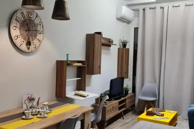 a living room with a table and a clock on the wall at Design drop in Athens ' center in Athens